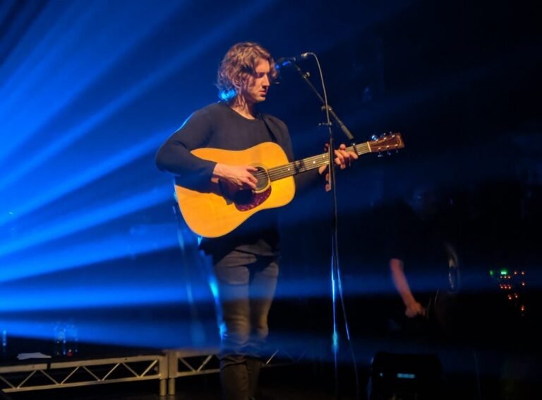 guitarrista tocando acordes en un escenario
